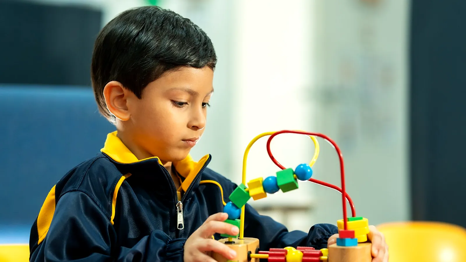 Estudiante de preescolar jugando con material didáctico